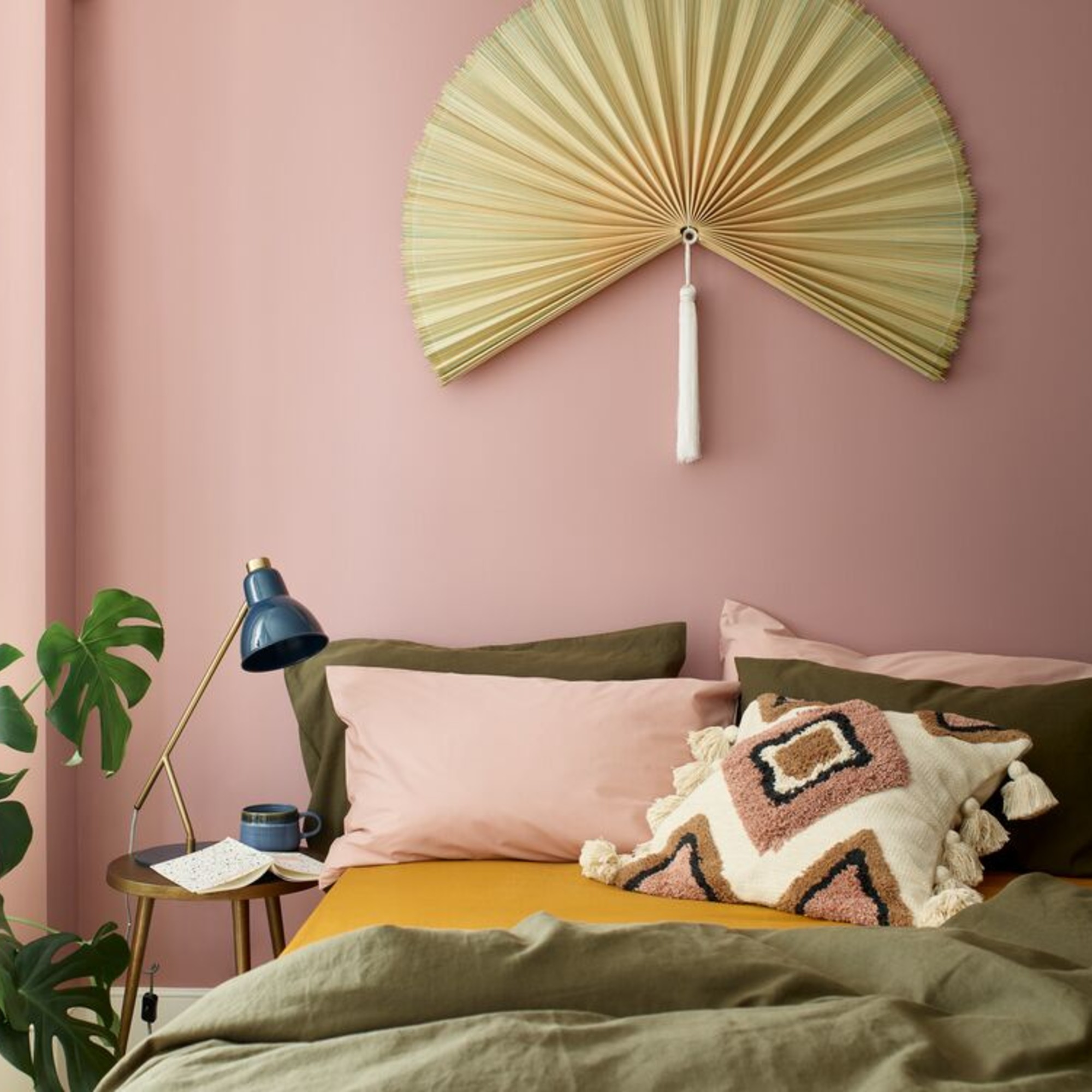 A pink bedroom painted in Pressed Petal by Dulux with pink and green bed linen on the bed