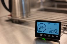 Smart meters: a smart meter appears in front of a stainless steel kettle