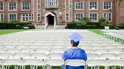 A college student sits in cap and gown ready to graduate.