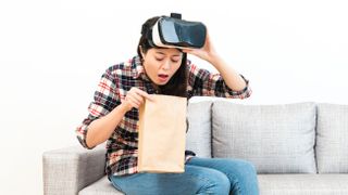 LADY with VR headset throwing up into bag. 