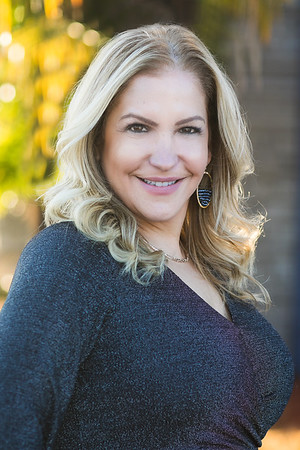 A headshot of Elle Nesher with long-sleeved navy blue top