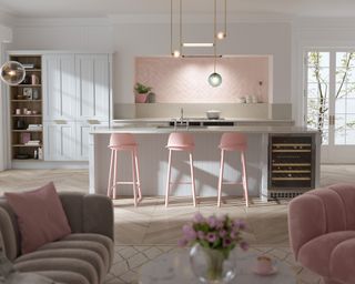 Baby pink and white country kitchen with breakfast bar stools