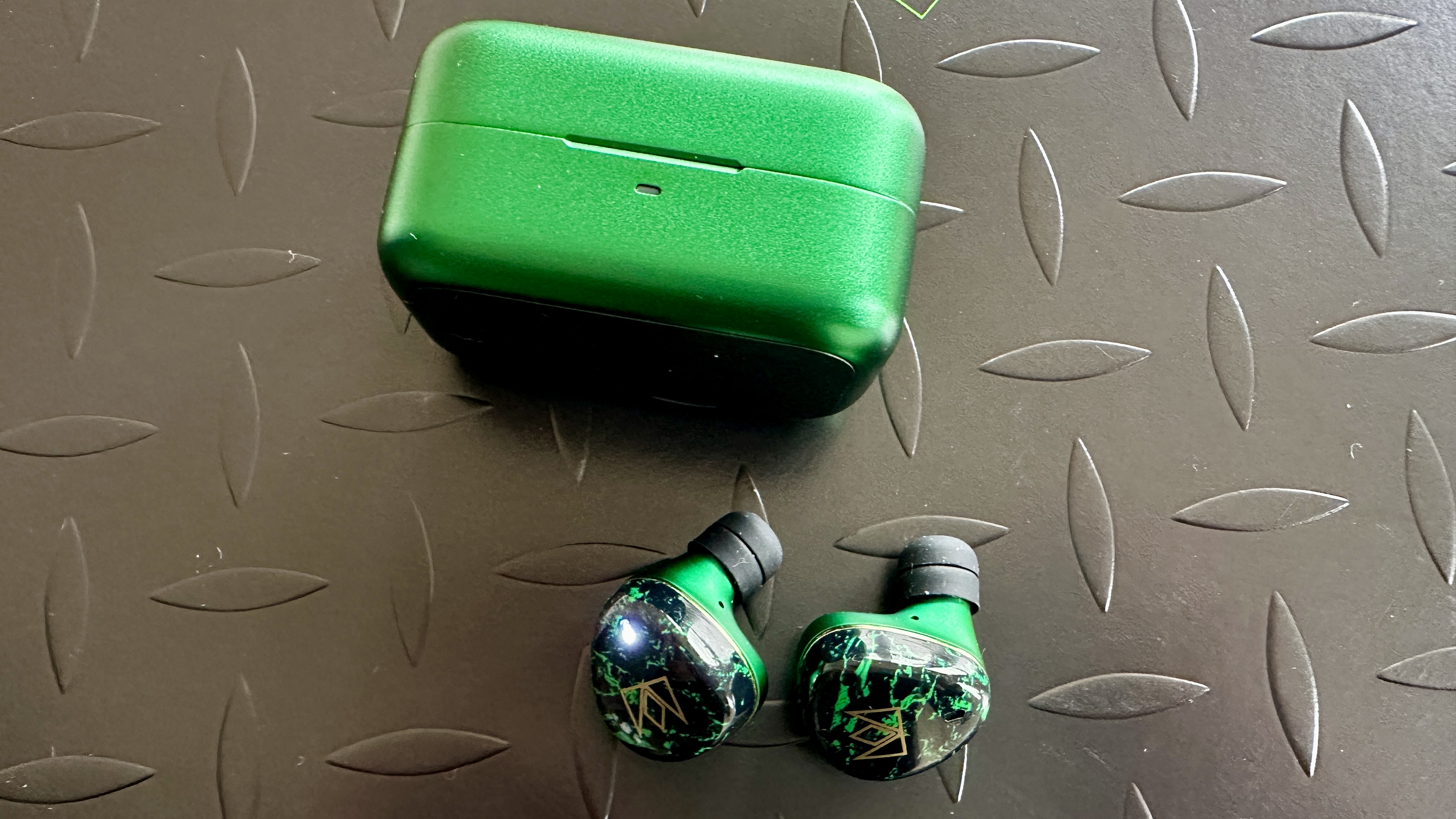 Noble FoKus Rex5 earbuds and travel case on a metallic surface