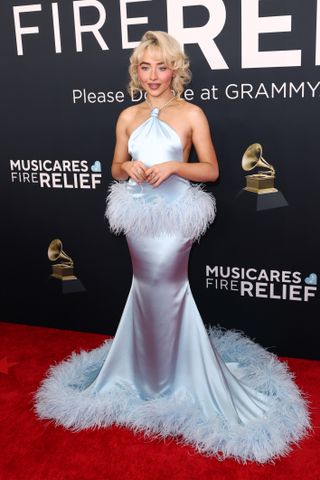 A photo of Sabrina Carpenter wearing a baby blue silk and feather gown from JW Anderson at the 2025 Grammys.