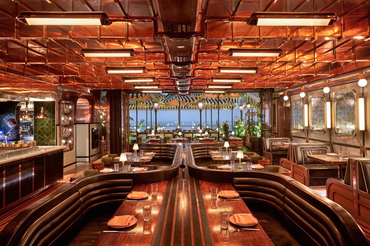 Gleaming copper and polished wood restaurant interior with a nautical theme.
