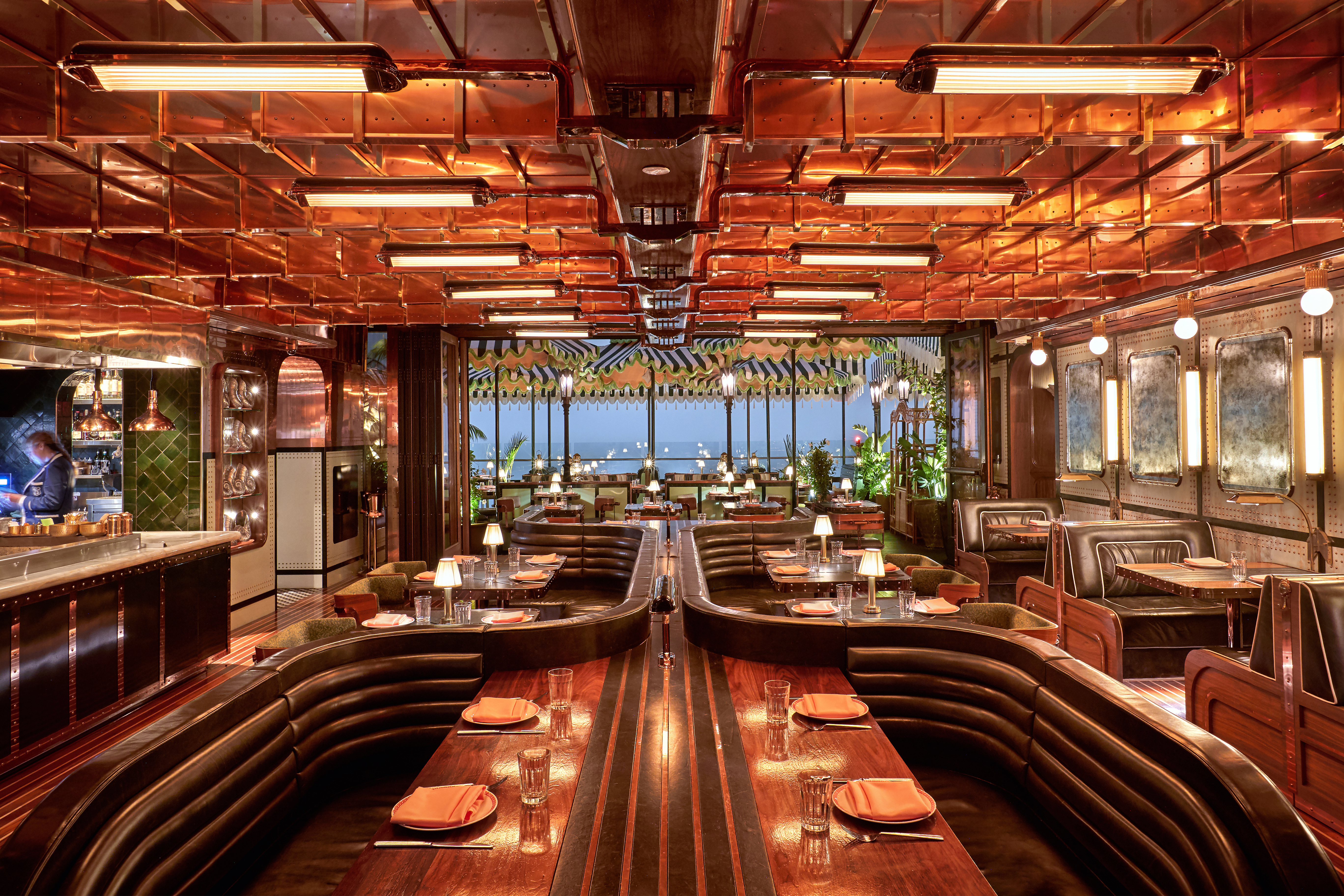 Gleaming copper and polished wood restaurant interior with a nautical theme.