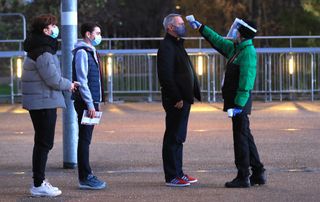 West Ham fans have their temperature taken as they arrive at the London Stadium for the match with Manchester United