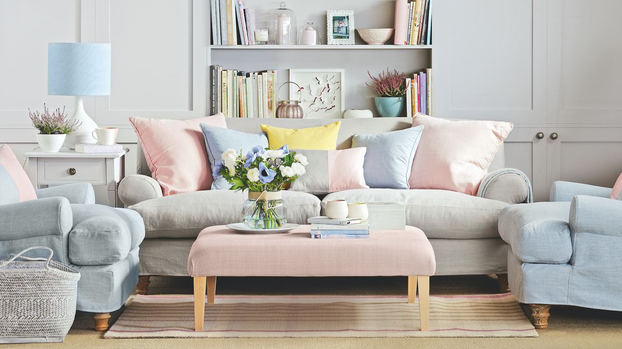 pale blue sofas with pink cushions and ottoman and fitted cupboards behind