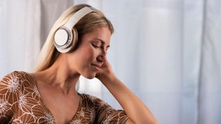 Woman listening on Cleer Audio Enduro 100 headphones.
