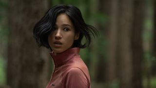 Kelsey Asbille&#039;s Iris looking over her shoulder in a forest in Don’t Move, one of October&#039;s new Netflix movies