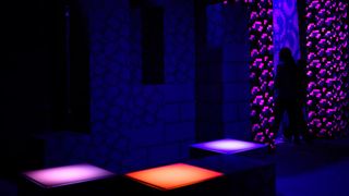 Someone stepping into a Nether portal with glowing squares in the foreground.