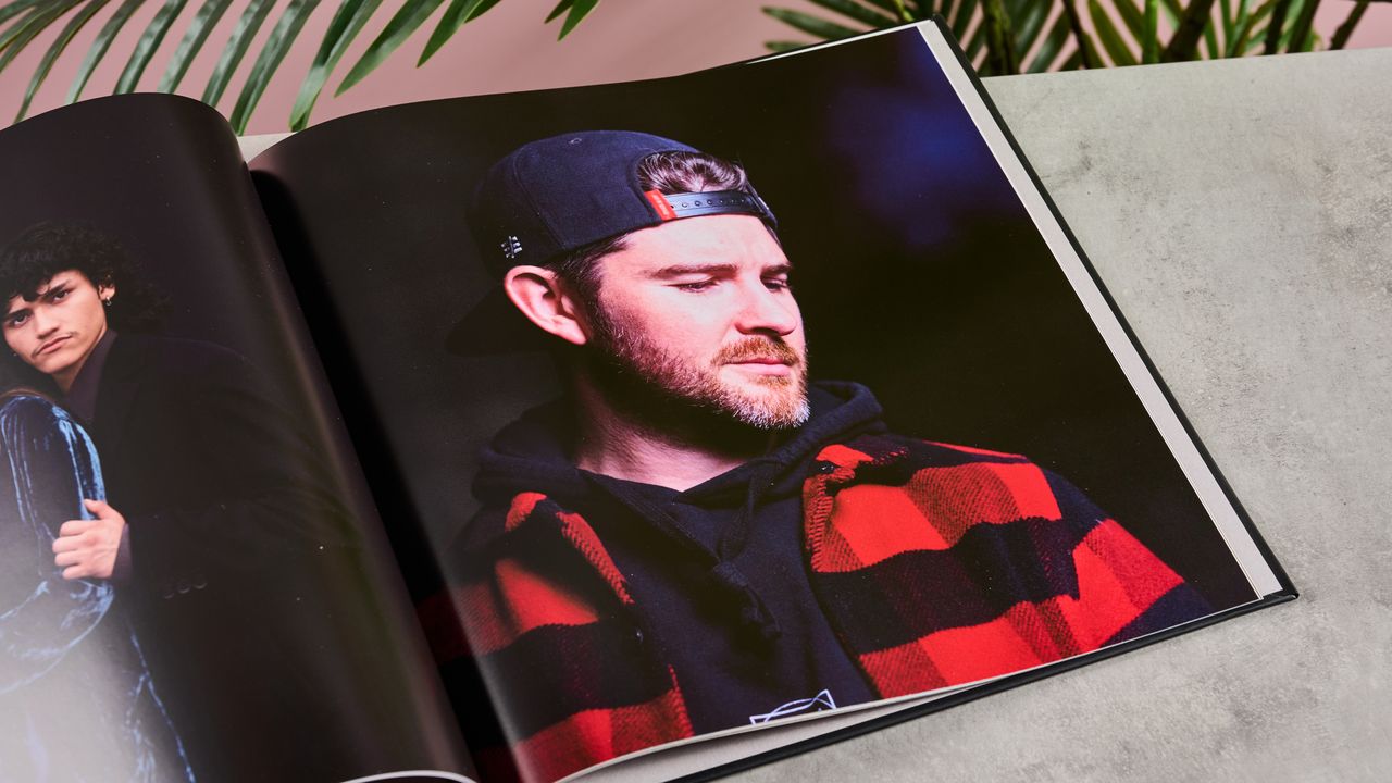 The interior of Blurb photo book showing a man wearing a backward baseball cap, checked shirt and a well-kempt beard.