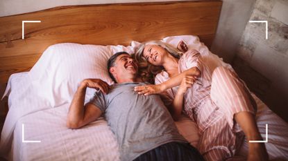 Man and woman lying in bed laughing and joking together, representing the leapfrog sex position