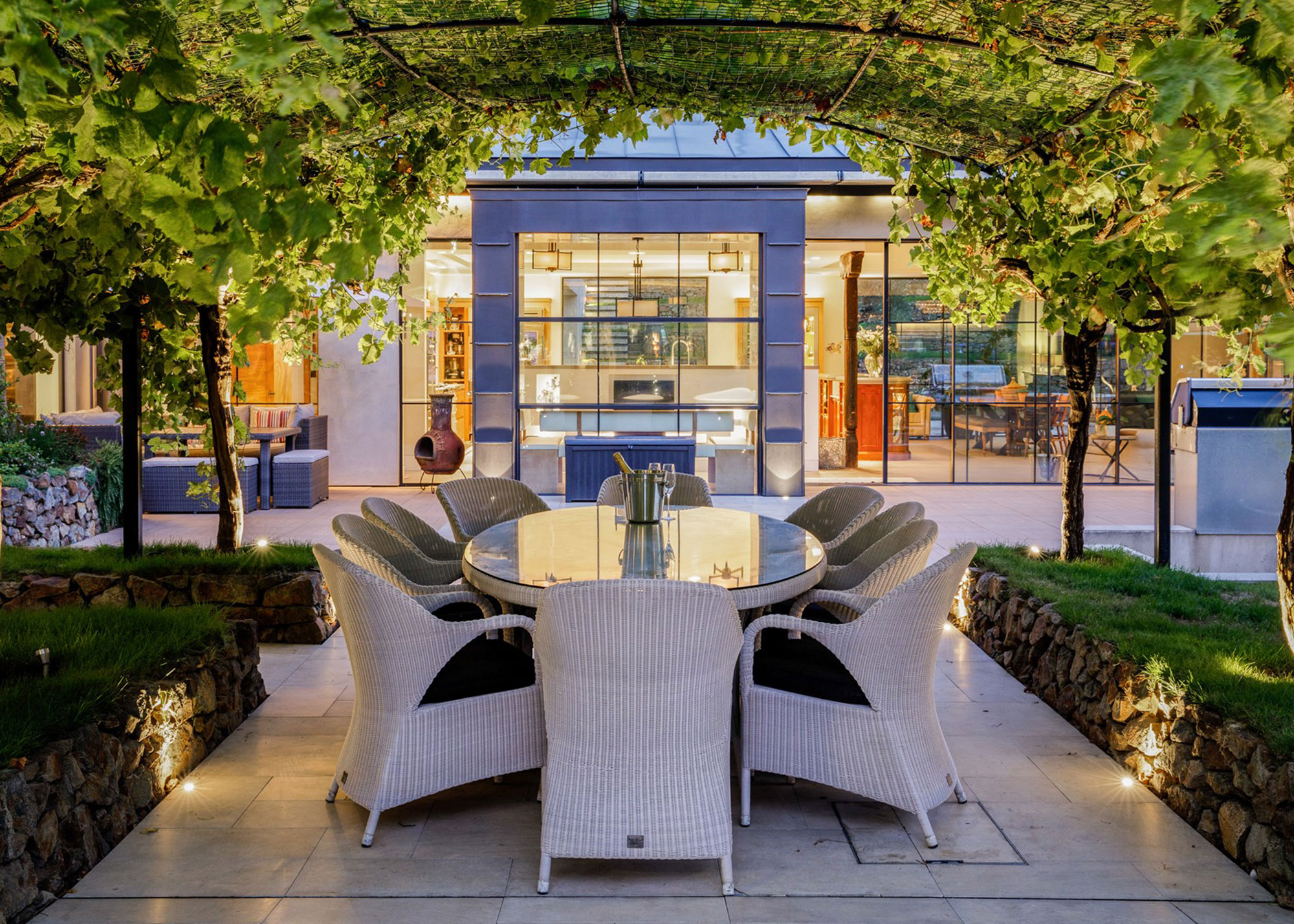 modern outdoor dining area with layered lighting scheme
