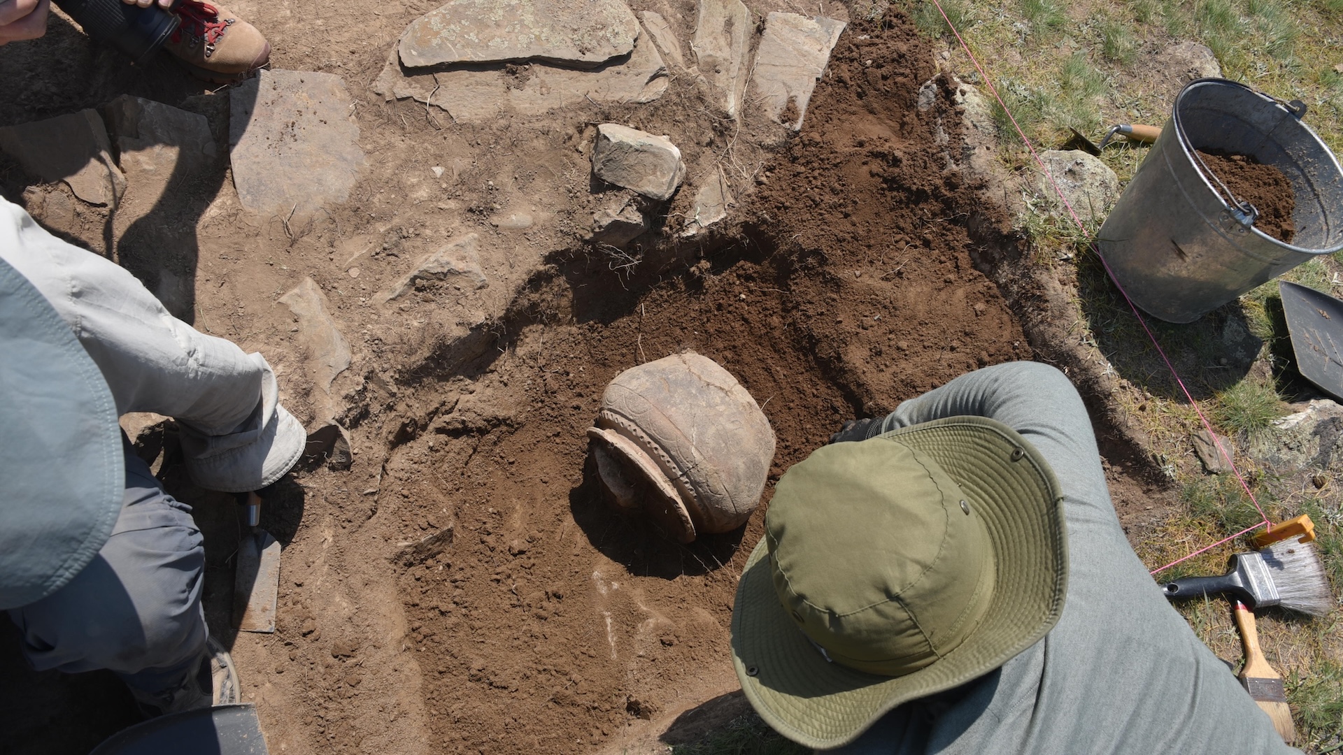 People excavate a piece of pottery from the ground