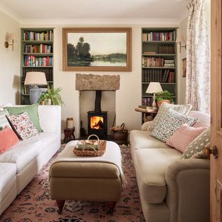 compact country living room with neutral walls, wood burner, alcove shelving sofas and footstool used as coffee table