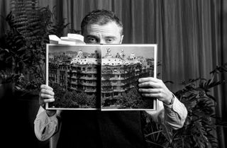 Thomas Heatherwick holding out book on spread with gaudi work