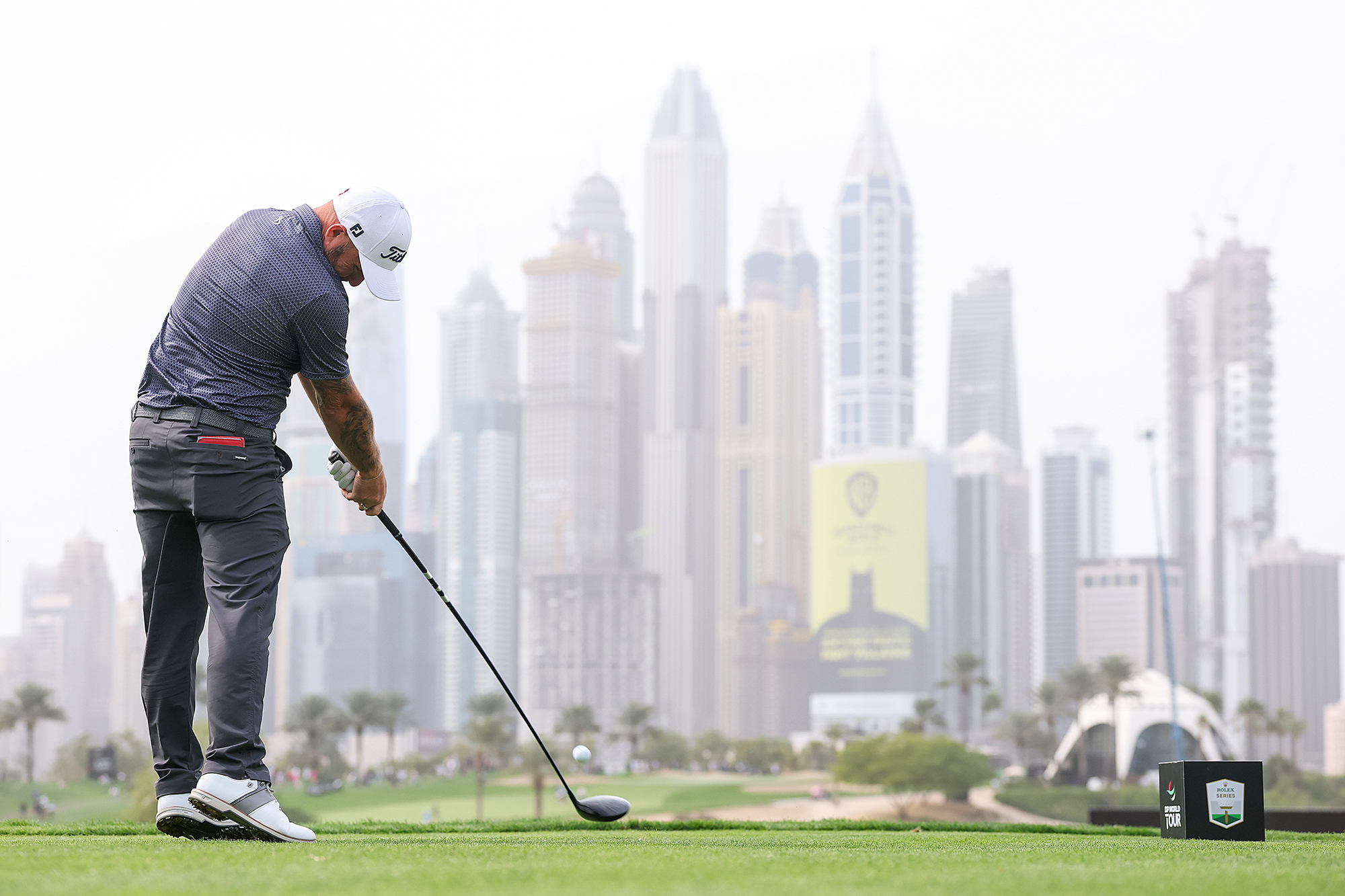 Andy Sullivan at impact hitting a driver against a backdrop of the Dubai skyline at the Dubai Desert Classic 2026