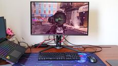 Gigabyte Aorus FO32U2P gaming monitor on a desk beside a laptop