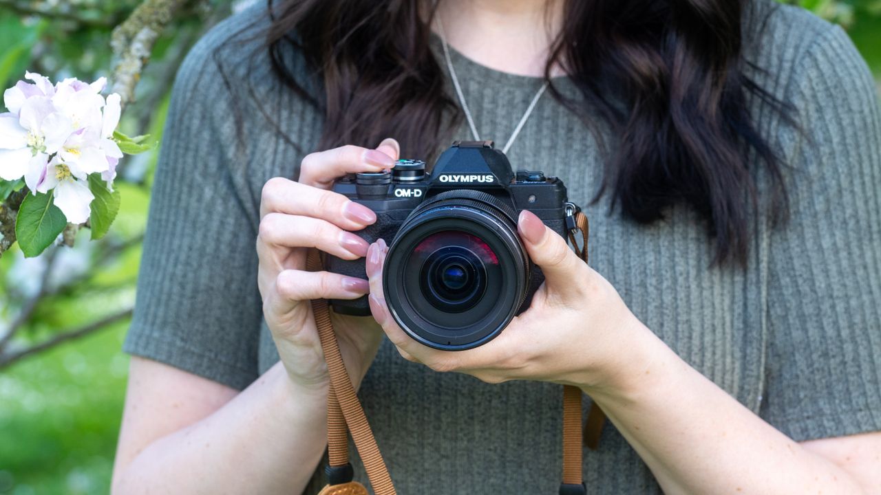 woman holding the Olympus OM-D E-M10 Mark IV
