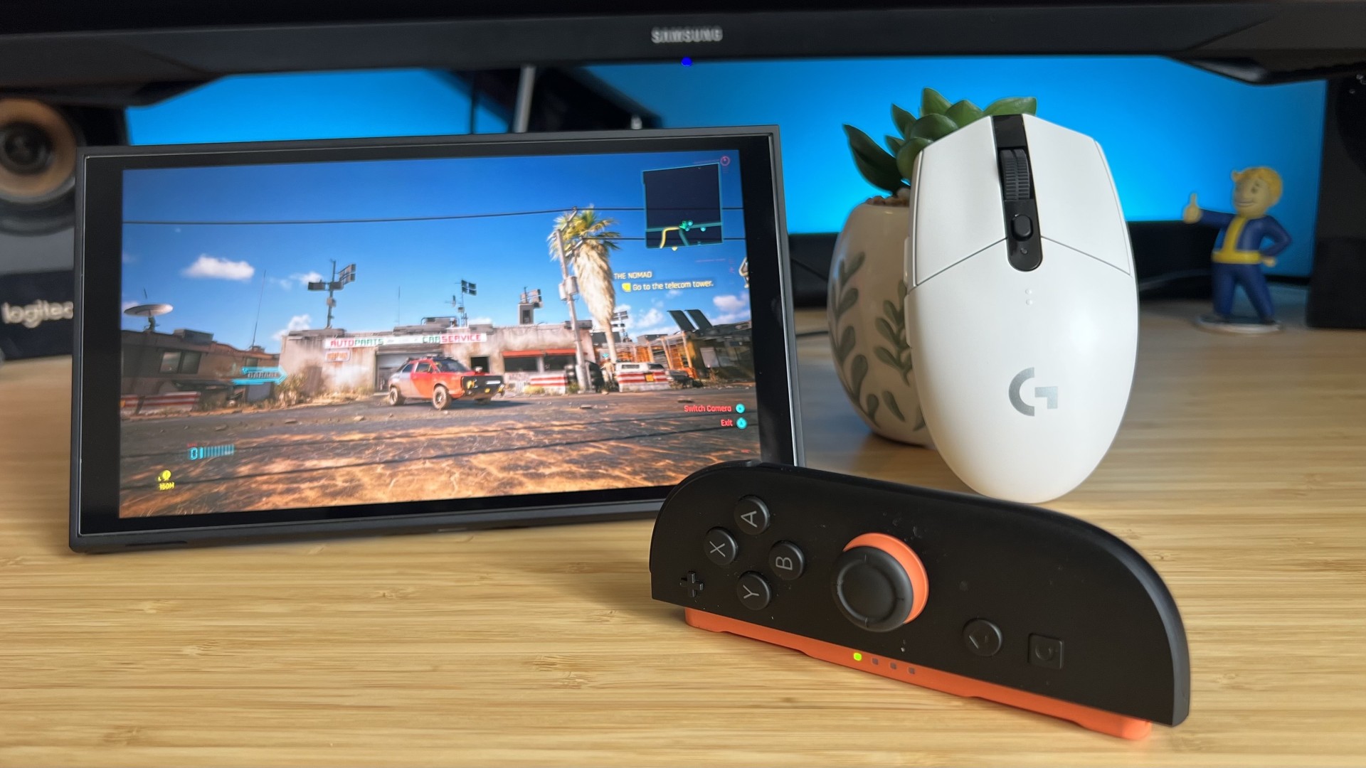 Nintendo Switch 2 using Joy-Con as mouse controls on a wooden desk with a white Logitech gaming mouse in the background