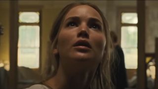 Jennifer Lawrence looks up with a questioning face while standing in a house in mother!