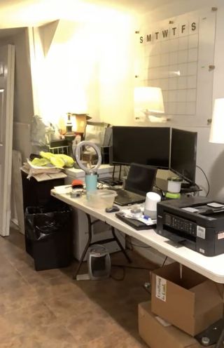 A fold-out desk cluttered with home office supplies