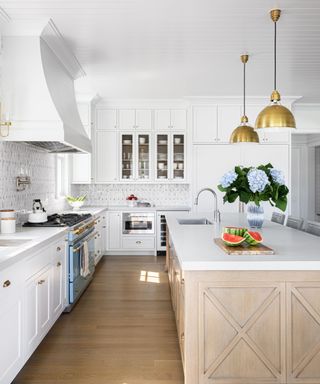 kitchen with white cabinets and pale wood island white cooker hood