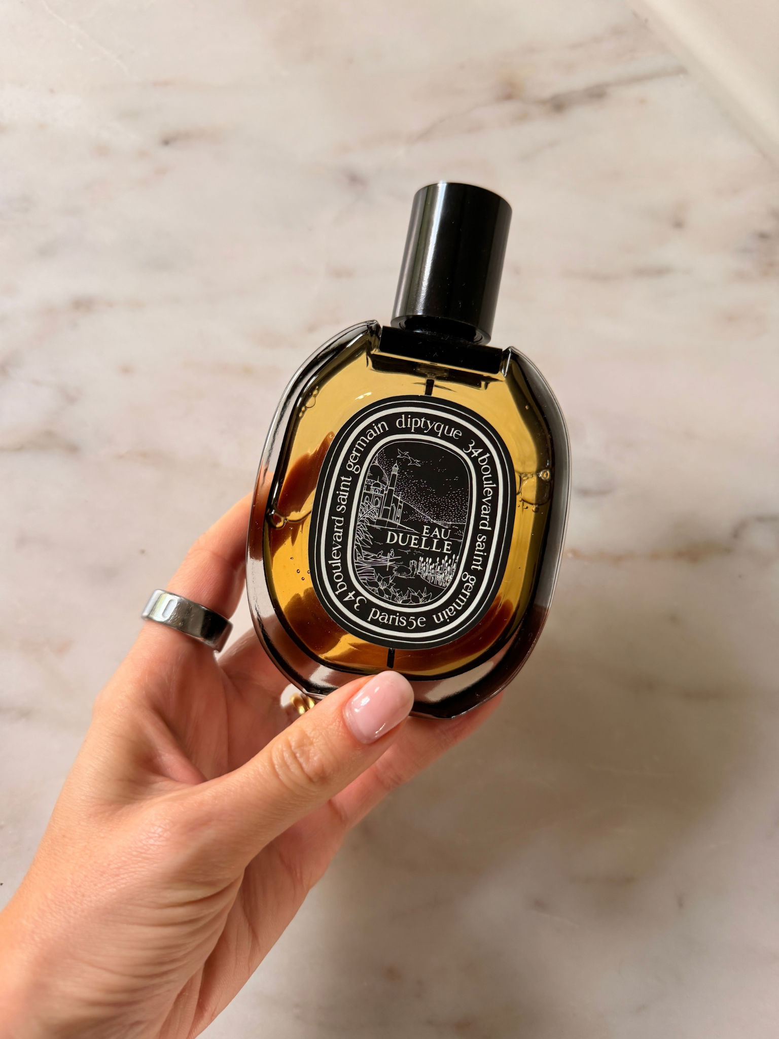 Freelance beauty editor Grace Day holding a bottle of Diptyque Eau Duelle Eau de Toilette