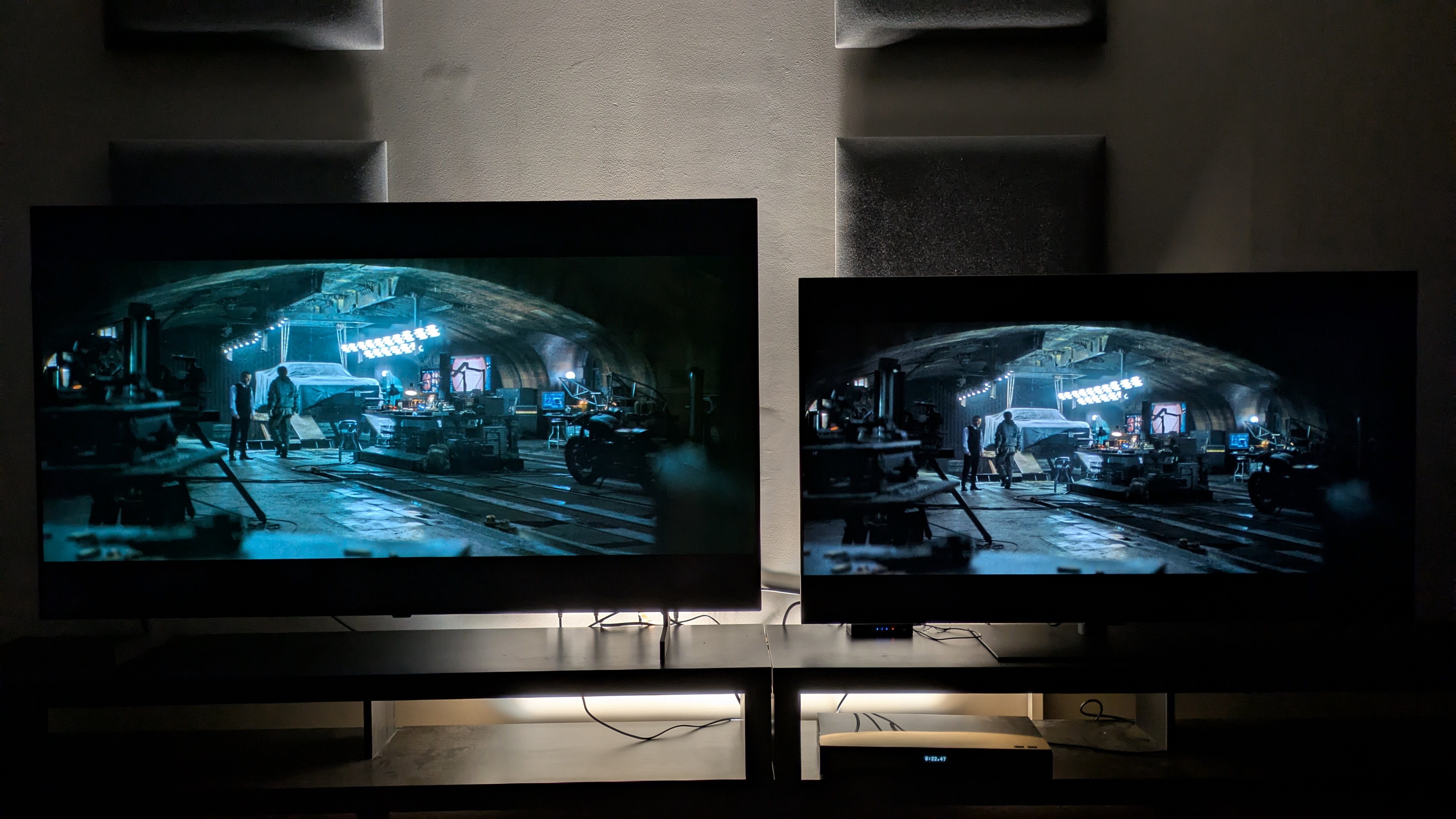 The LG B6 (left) and LG G6 (right) showing The Batman, where Bruce walks past Alfred in the Batcave. Both TVs show strong contrast and while the B6 may look brighter, it's showing signs of clipping.
