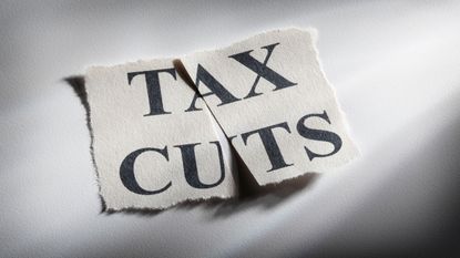 picture of a piece of paper with "Tax Cuts" written on it that has been cut in half