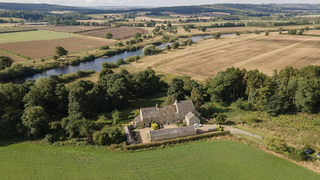 a large farmhouse in the middle of a field