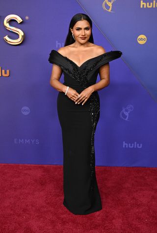 Mindy Kaling wears a black off-the-shoulder dress