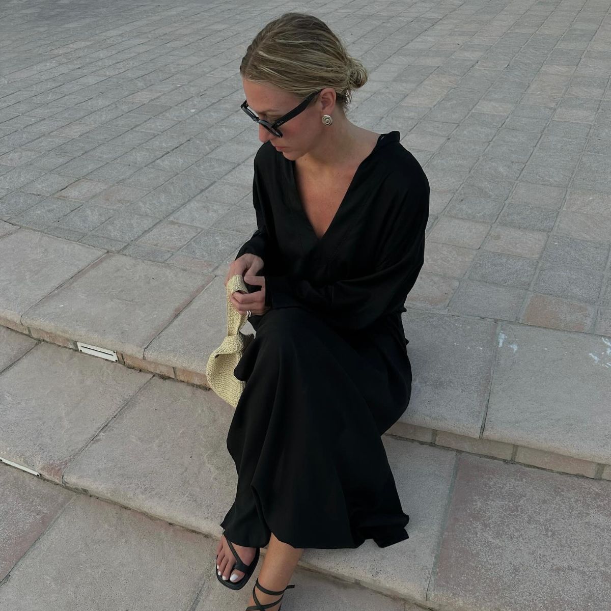 Woman wears black dress, yellow bag and black sandals 