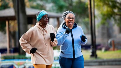 Two women power walking in a park in winter