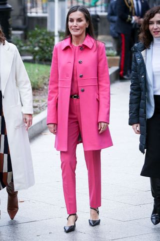 Queen Letizia wearing a pink coat, top and trousers