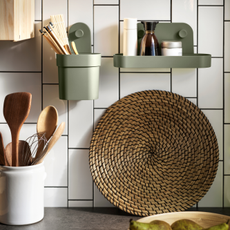 IKEA OBONAS shelf and container in green holding kitchen utensils and seasonings.