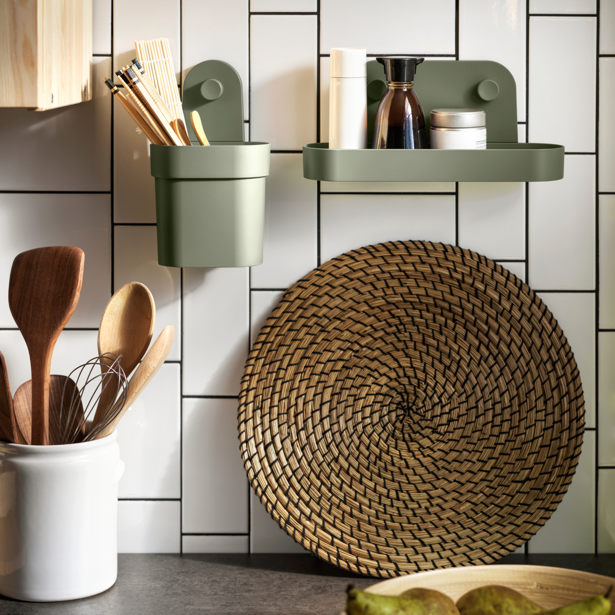 IKEA OBONAS shelf and container in green holding kitchen utensils and seasonings.