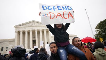 participant holding a protest sign at the rally immigration