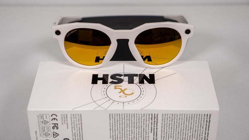 Warm white Oakley Meta HSTN smart glasses with its box and charging case on a white table