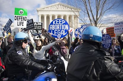 Pro-life and pro-choice activists protest in front of the Supreme Court.
