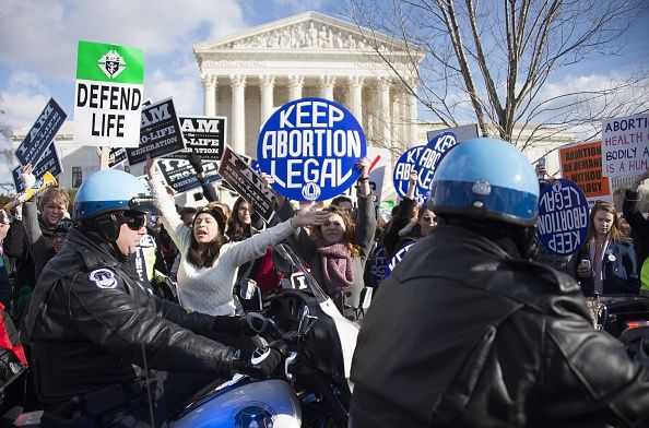 Pro-life and pro-choice activists protest in front of the Supreme Court.