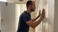 Man performing wall push-ups at home