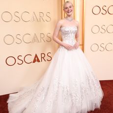 Elle Fanning wearing a white custom Givenchy by Sarah Burton gown with Cartier jewelry on the red carpet at the 2026 Oscars. 