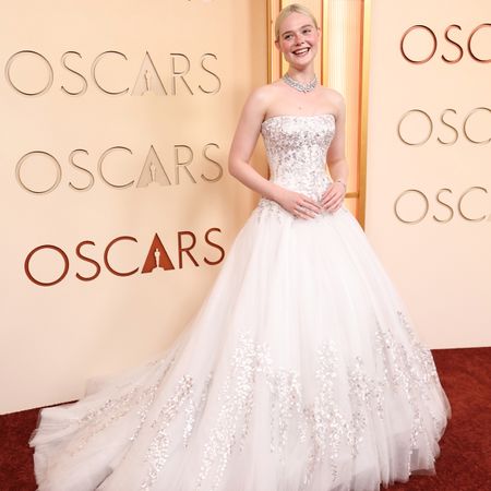 Elle Fanning wearing a white custom Givenchy by Sarah Burton gown with Cartier jewelry on the red carpet at the 2026 Oscars.