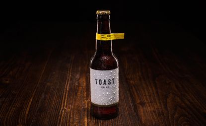 A bottle of "TOAST" beer on dark wood