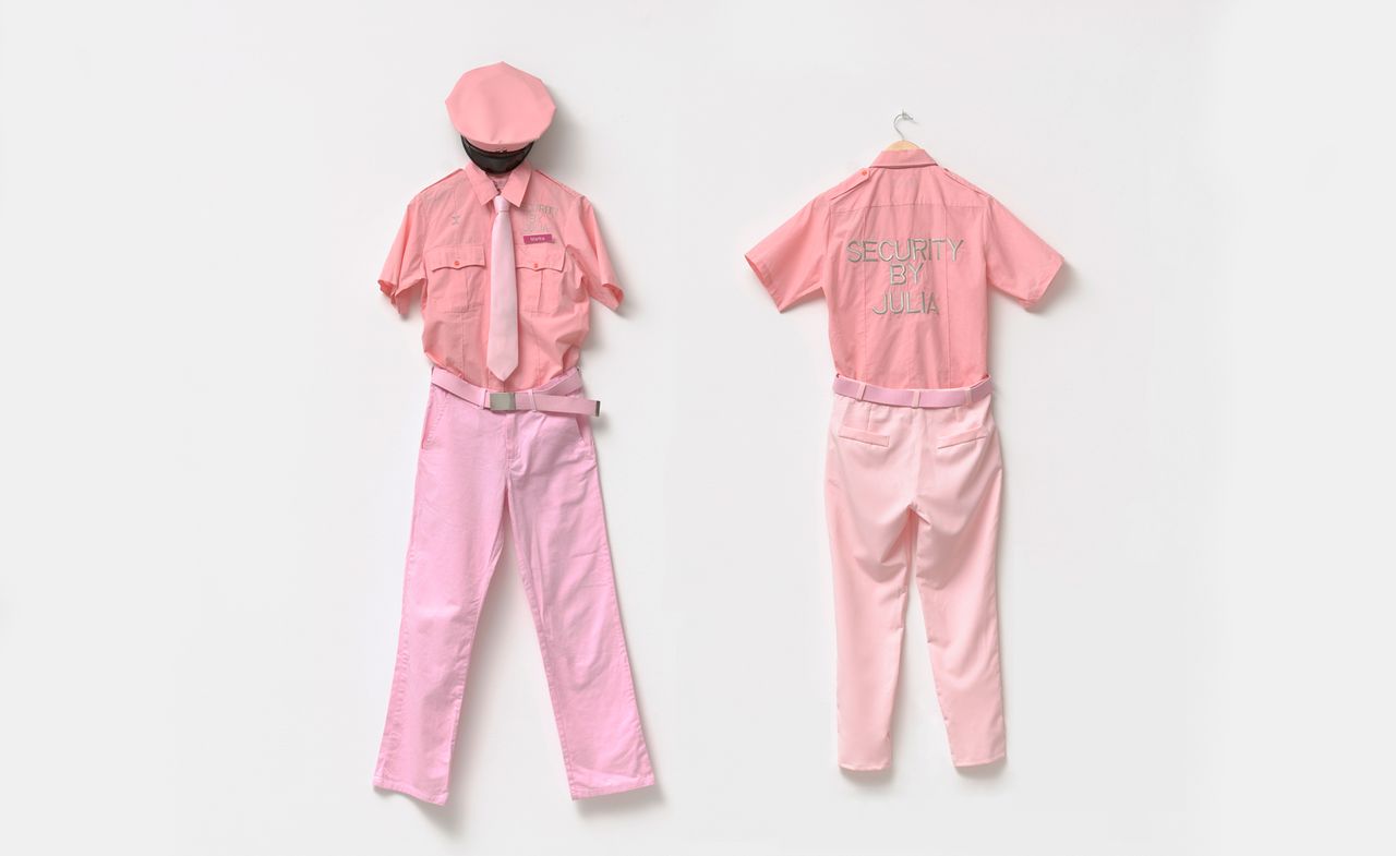 Pink uniforms on wall as part of &#039;Day Jobs&#039; exhibition at Cantor Arts Center