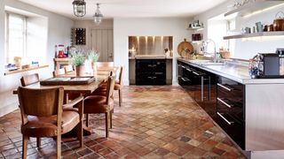 brown stone kitchen floor with large wooden kitchen table