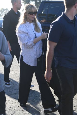 Jennifer Lawrence layers a pendant necklace with a striped button-up shirt.