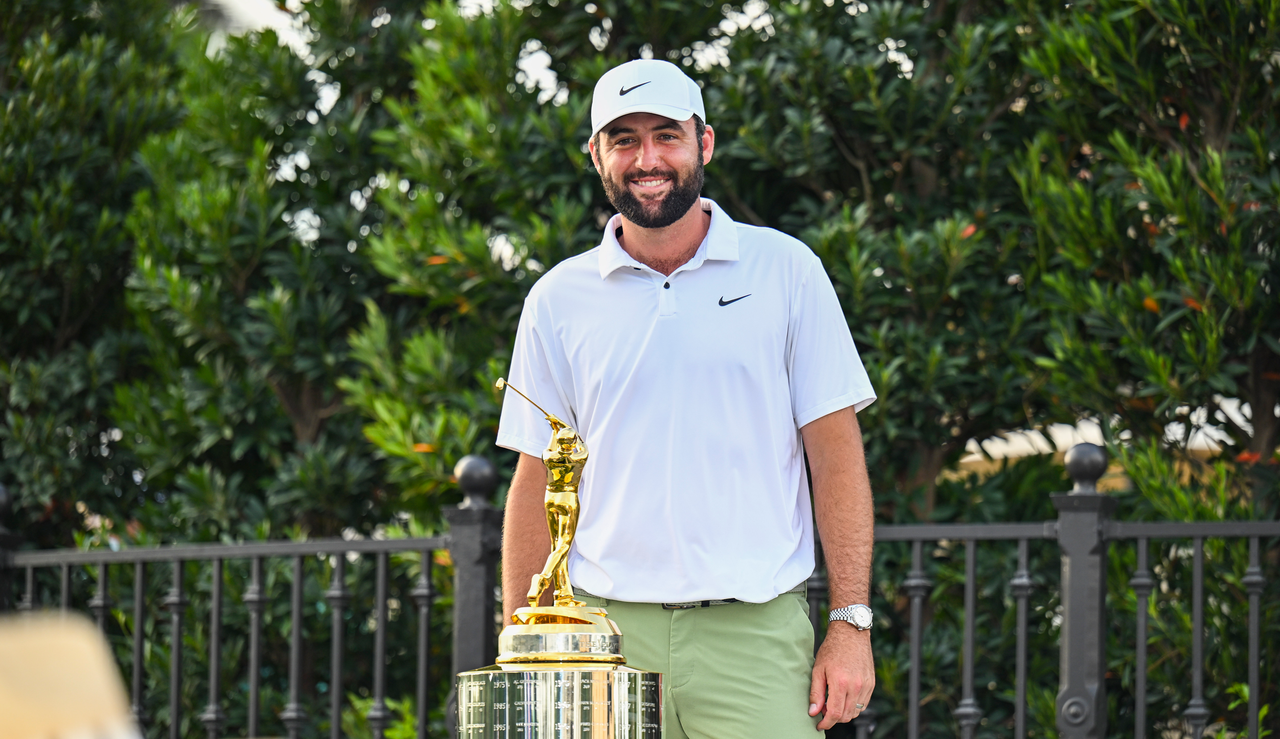 Scottie Scheffler stands behind The Players Championship trophy